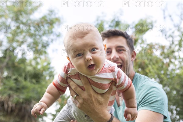 Caucasian father playing with baby outdoors