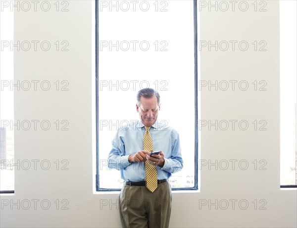 Caucasian businessman using cell phone in office