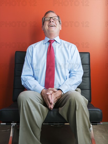 Caucasian businessman laughing in chair