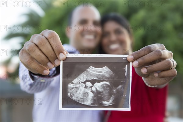 Happy couple holding sonogram