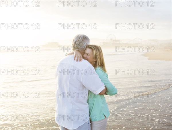 Caucasian couple hugging on beach