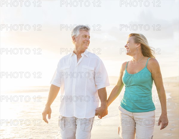 Caucasian couple walking on beach