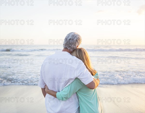 Caucasian couple hugging on beach