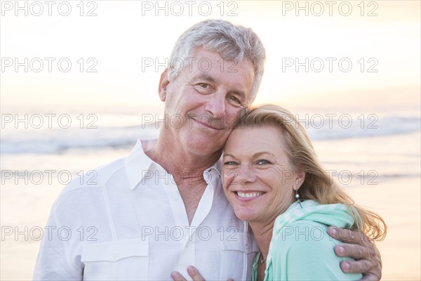 Caucasian couple hugging on beach