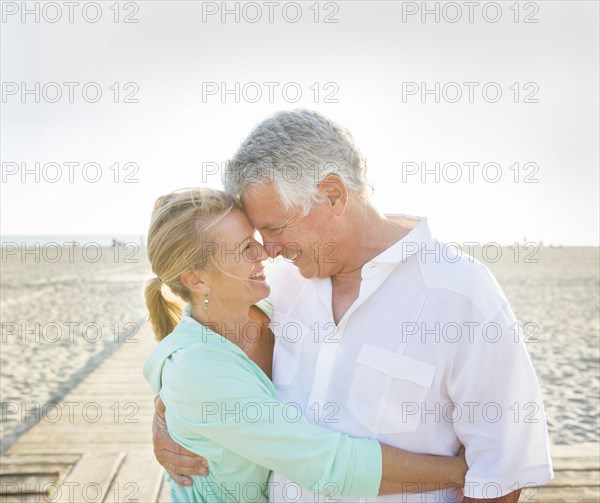 Caucasian couple hugging on beach