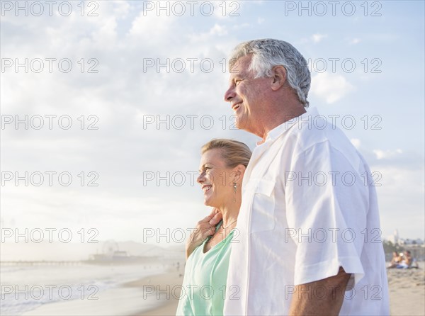 Caucasian couple hugging on beach