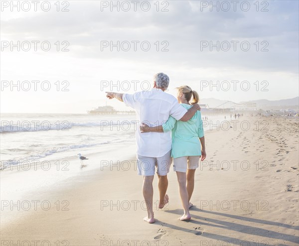 Caucasian couple walking on beach