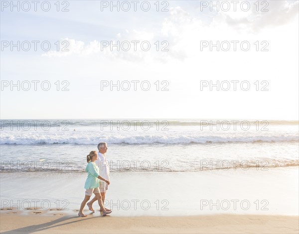 Caucasian couple walking on beach