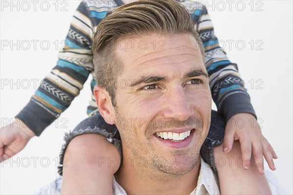 Close up of Caucasian father holding son on shoulders