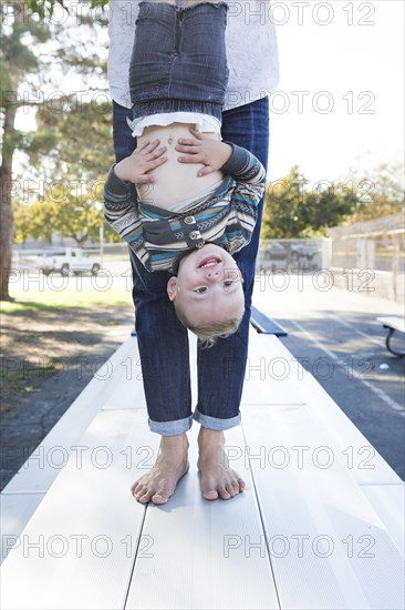 Caucasian father and son playing on picnic table