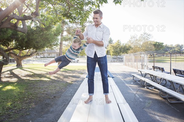 Caucasian father and son playing on picnic table