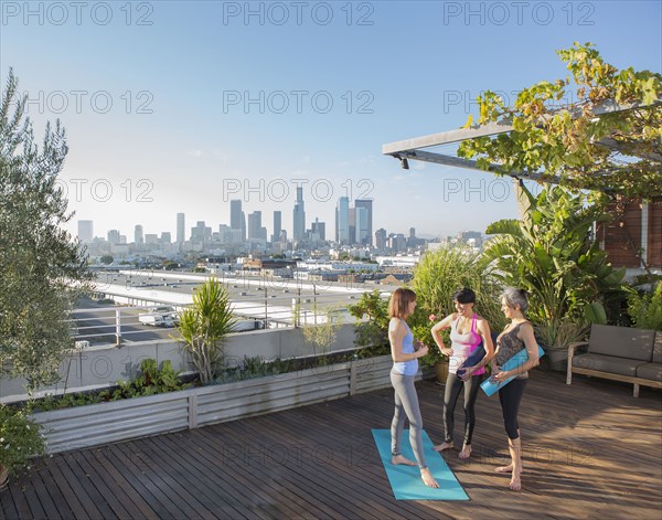 Women talking after practicing yoga on urban rooftop