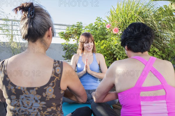 Teacher working with yoga students outdoors