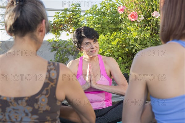 Teacher working with yoga students outdoors