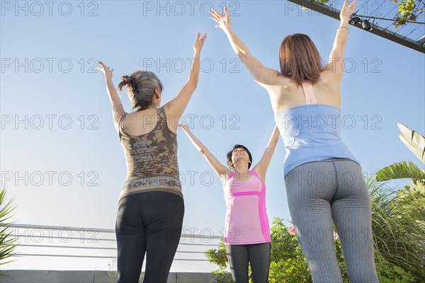 Teacher working with yoga students in class outdoors