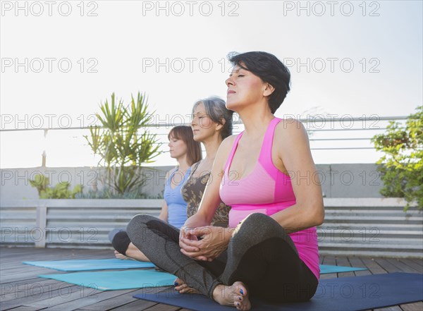 Women meditating together on rooftop