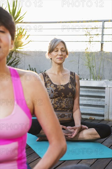 Women meditating on rooftop