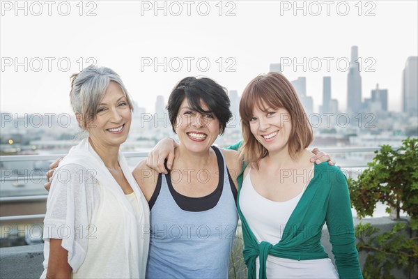 Women smiling together on urban rooftop