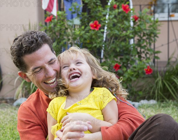 Caucasian father and daughter playing in backyard