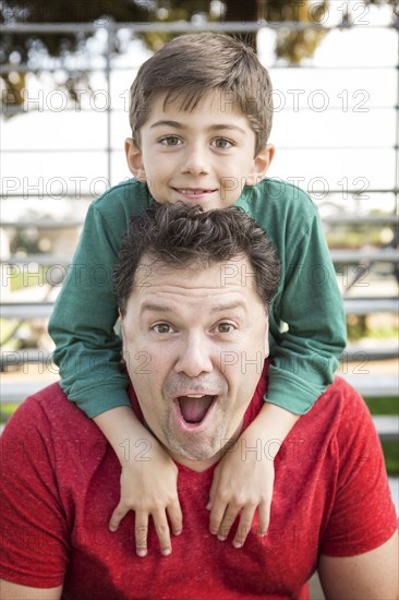 Caucasian father and son playing on bleachers