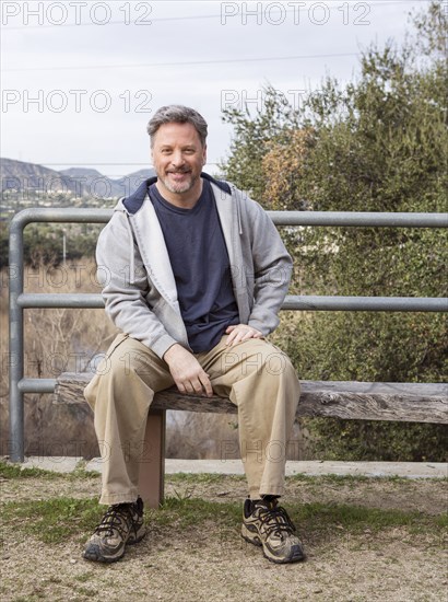 Caucasian man sitting on bench in park