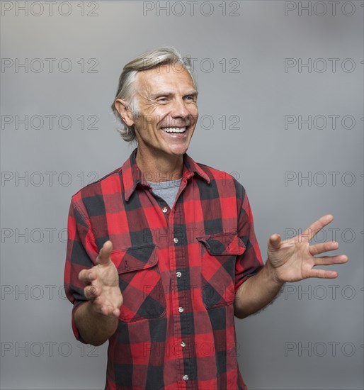 Smiling older Caucasian man gesturing