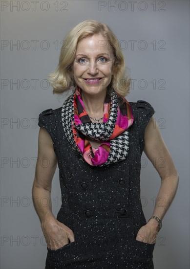 Smiling Caucasian woman standing with hands in pockets