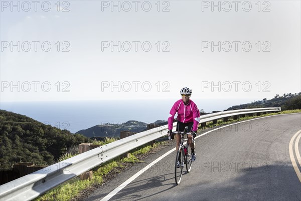 Caucasian woman biking on remote mountain road