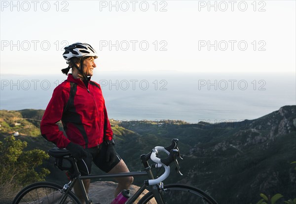 Caucasian woman with bicycle admiring scenic view of mountains