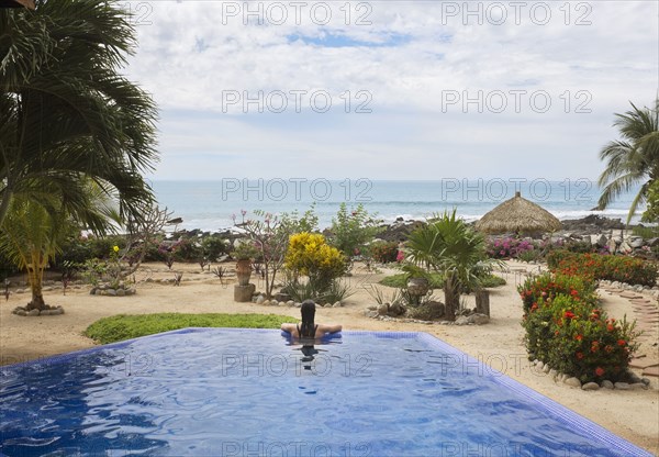 Hispanic woman relaxing in swimming pool