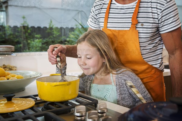 Caucasian father and daughter cooking in kitchen