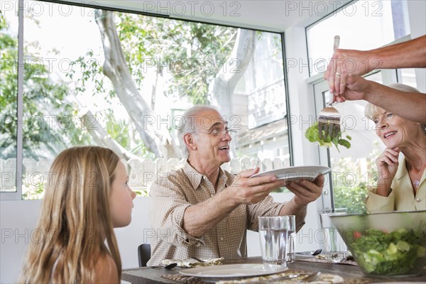 Caucasian multi-generation family eating at table