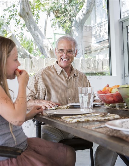 Caucasian multi-generation family eating at table