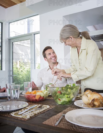 Caucasian mother serving son at table