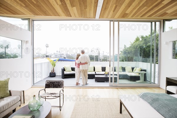 Older Caucasian couple hugging on porch