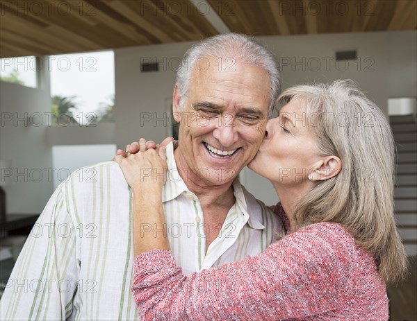 Close up of older Caucasian woman kissing husband