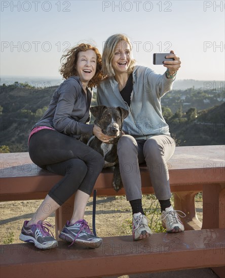 Caucasian women taking selfie on hilltop