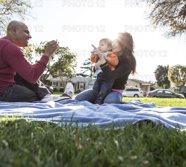 Hispanic family on blanket in park