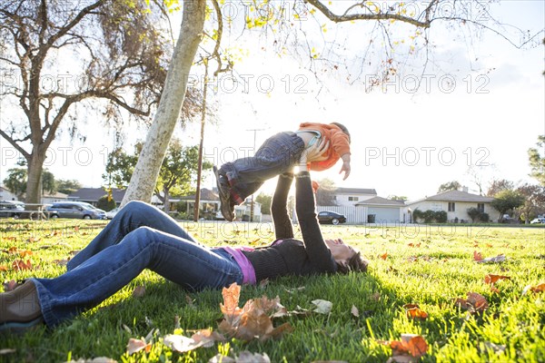 Hispanic mother playing with son in park