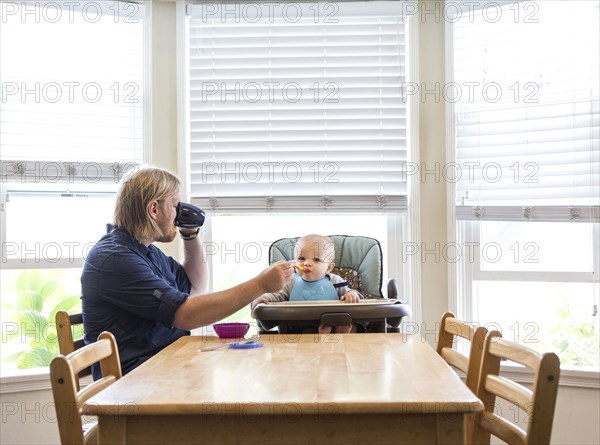 Caucasian father feeding son in high chair