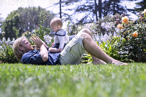 Caucasian father and son playing in grass