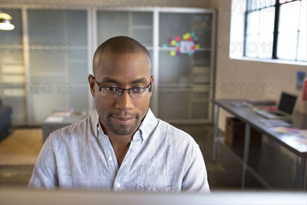 Mixed race businessman using computer in office