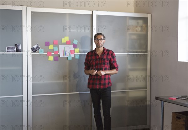 Caucasian businessman standing by cabinet in office