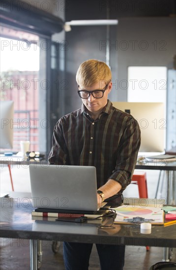 Caucasian businessman working on laptop in office