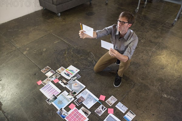 Caucasian businessman examining paperwork on office floor