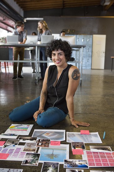 Businesswoman examining paperwork on office floor