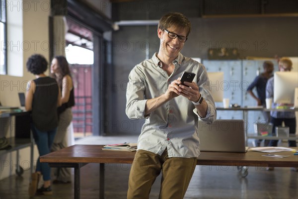 Businessman using cell phone in office