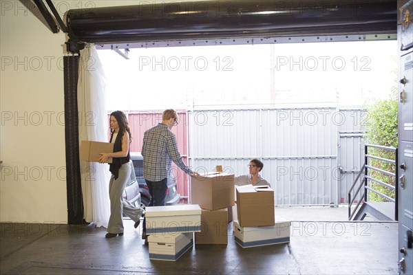 Caucasian business people unpacking boxes in new office