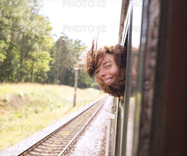 Hispanic woman with head out train window