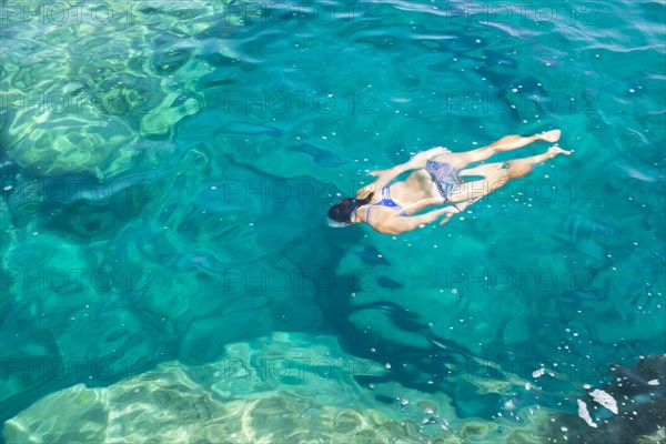Hispanic woman swimming in ocean